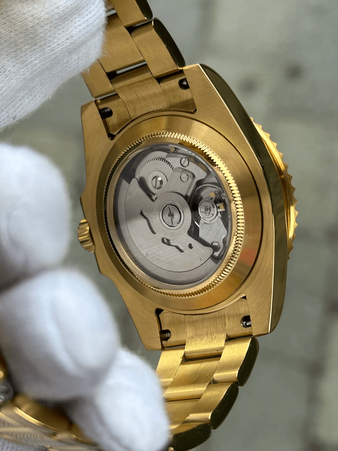 Marinetime Ocean Gold představuje vrchol luxusu v naší potápěčské kolekci. Kompletní zlaté provedení v kombinaci s hlubokým modrým číselníkem vytváří působivý kontrast, který upoutá pozornost v každé situaci. Safírové sklo chrání nádherný modrý sunburst číselník, který dynamicky mění svůj odstín v závislosti na úhlu dopadu světla. Modrá keramická luneta se zlatými indexy dokonale ladí s celkovým designem a poskytuje přesnou časomíru při potápění. Pod průhledným deklem můžete obdivovat spolehlivý automatický strojek NH35, který je zárukou přesného chodu. Zlacené pouzdro a integrovaný náramek jsou zpracovány s mimořádnou pozorností k detailu, aby zajistily dlouhodobou trvanlivost povrchové úpravy.